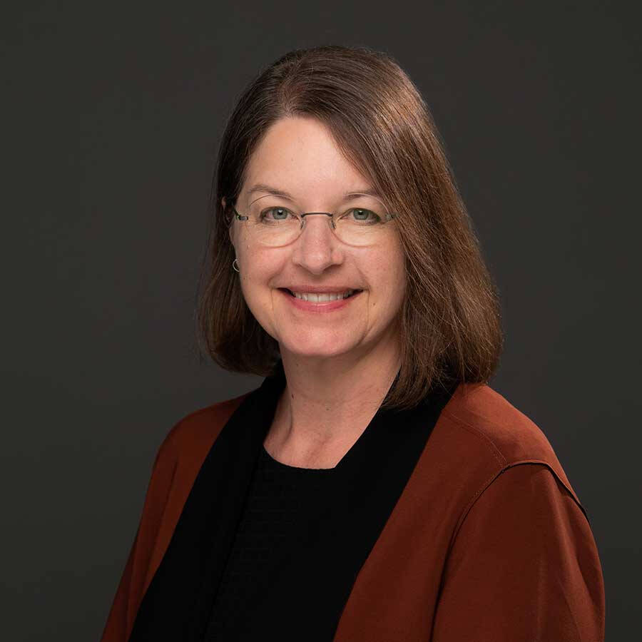 Dr. Rener wearing a red cardigan and a black top